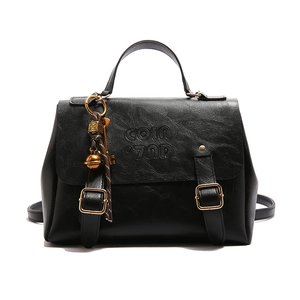 Retro black leather briefcase with gold buckles and chic charms on white background