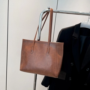 Vintage brown leather tote bag for women featuring vertical stitching and large capacity