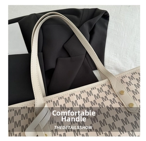 Close-up of comfortable leather handle with metal rivets on monogram tote bag