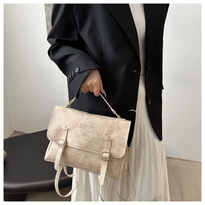 Detail of beige vintage laptop bag with flap closure and lucky LHCO smu embossed logo