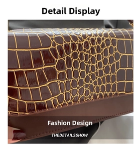 Detailed close-up of dark brown crocodile texture with golden accents on a retro shoulder bag