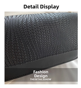 Detail of cross-weave pattern and leather trim stitching on black minimalist shoulder bag