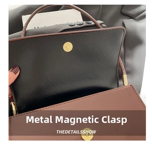 Detail of the golden magnetic hardware clasp on a brown crocodile pattern shoulder bag