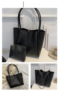 Detail of black leather tote bag with matching zipper pouch and long handles