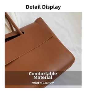 Macro view of brown leather tote showing fine stitching details and handle attachment