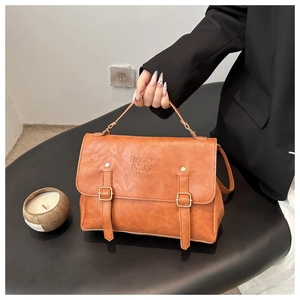 Detail of vintage brown leather backpack with golden buckles and embossed lucky lettering