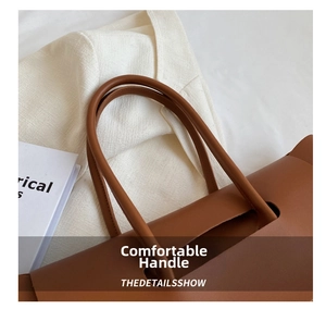 Macro view of handle attachment on brown leather tote with minimalist craftsmanship