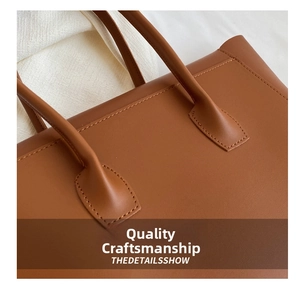 Close-up of the meticulous stitching on a brown leather tote bag handle and body detail