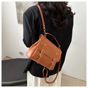Detailed view of brown vintage messenger bag with metal buckles and leather texture