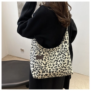 Detailed close-up of leopard print corduroy tote bag with side fashion leather label