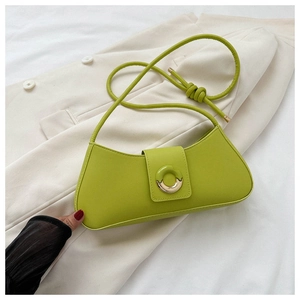 Detail of lime green leather shoulder bag with decorative resin buckle on beige blazer