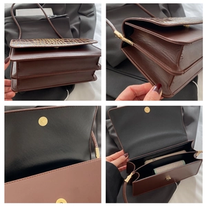 Macro view of dark brown leather handbag showing accordion structure and magnetic closure