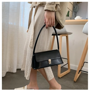 Gros plan d'un sac à main noir élégant avec un fermoir en métal doré texturé