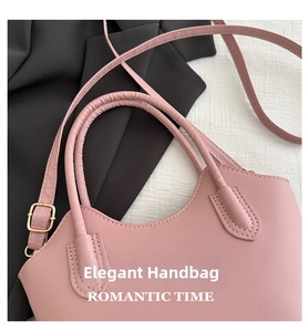 Close-up of pink faux leather bucket bag with round handle and gold buckle details