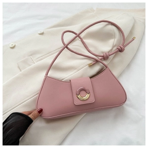 Detail of a dusty pink leather crescent shoulder bag with a unique circular metal buckle