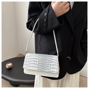 Détail du sac à bandoulière blanc avec rabat motif crocodile et boucle dorée