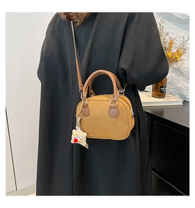 Yellow corduroy pillow bag with round leather handle and cute clown pendant detail