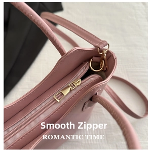 Close-up of smooth gold metal zipper and stitching on pink leather bucket bag