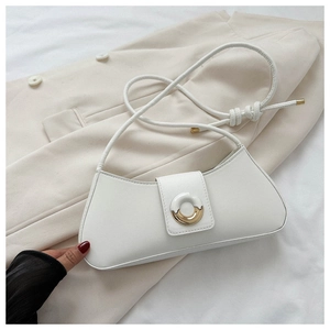 Detail of white leather shoulder bag with gold metal buckle on beige blazer jacket