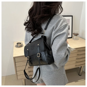 Detail view of black vintage leather backpack with adjustable straps and buckle closure
