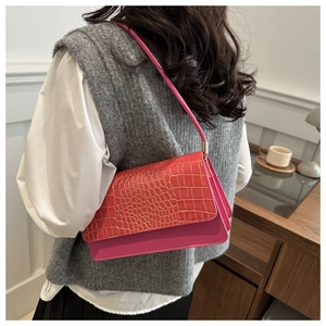 Sac sous le bras rose chic en similicuir crocodile porté par un mannequin pour style