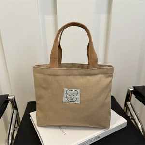 Minimalist canvas tote bag featuring cute bear patch and dark brown handles