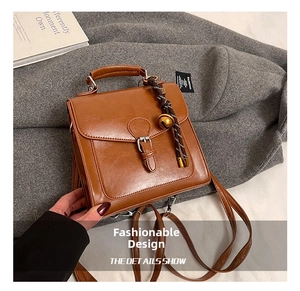 Dettaglio della pelle marrone vintage e del cinturino decorativo sulla borsa a spalla