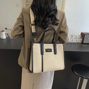 Grand sac cabas en toile beige avec bordure en cuir noir et large bandoulière amovible