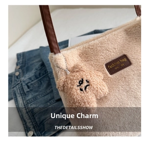 Close-up of fluffy cream plush bucket bag with brown leather strap and cute bear charm