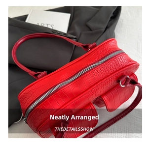 Macro detail of red crocodile embossed leather texture and metallic zipper on handbag
