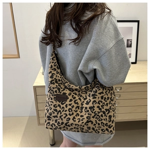Detail of leopard print tote bag in corduroy texture with fashion label shown on model