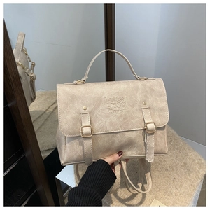 Detail of beige textured leather backpack with buckle straps and lucky logo embossing