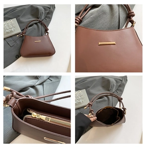 Détail du sac en cuir mat marron avec barre métallique dorée et bandoulière nouée