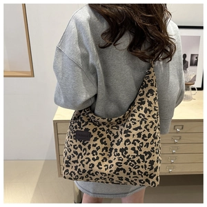 Detailed view of leopard print corduroy tote bag with brown FASHION label on model
