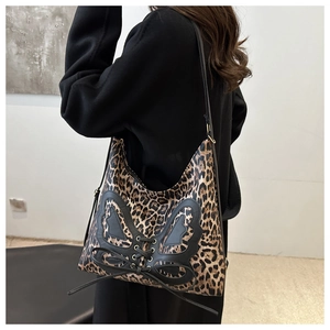 Détail du sac hobo léopard avec empiècement papillon en cuir noir et laçage croisé