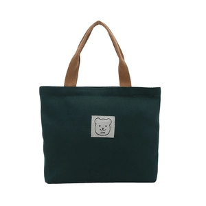 Sac à main en toile vert foncé avec anses marron et patch ours minimaliste
