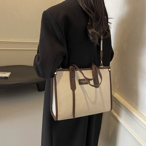 Grand sac cabas en toile beige avec bordure en cuir marron et bandoulière réglable