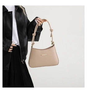 Détail du sac à bandoulière beige en similicuir avec bandoulière nouée et décor doré