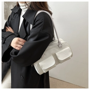 Side view of white faux crocodile leather shoulder bag with two front flap pockets