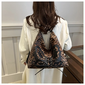 Detail of leopard print hobo bag featuring black leather bow and lace-up design