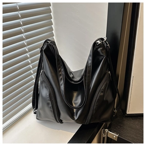 Detail shot of black soft PU leather tote bag with functional zippers and silver hardware