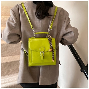 Zaino squadrato in ecopelle verde lime con ciondolo a campanella dorata e cinghie