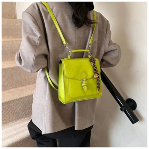Zaino e borsa a mano in pelle PU verde lime con ciondolo indossato da una modella