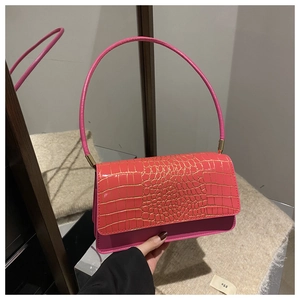 Detail of rose pink crocodile embossed leather texture on a chic shoulder underarm bag