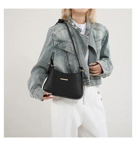 Détail du sac bandoulière en cuir PU mat noir avec fermoir doré et bandoulière nouée