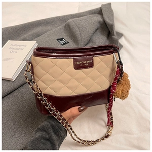 Detailed shot of quilted leather crossbody bag with chain strap and teddy bear charm