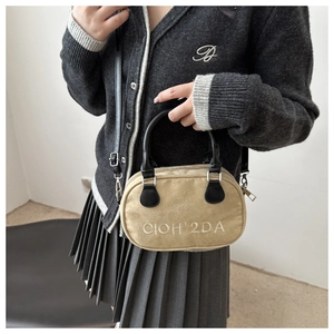 Detailed view of khaki suede bowling bag with white CIOH'2DA embroidery and black handles