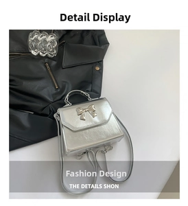 Close-up of silver mini handbag featuring a metallic bow and sleek trapezoid shape