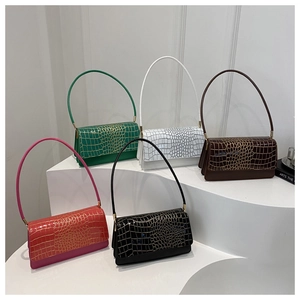 Detailed array of five colorful crocodile embossed shoulder bags on a minimalist white stand
