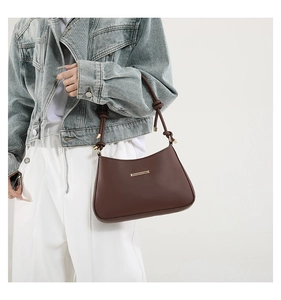 Détail du sac porté épaule marron avec bandoulière nouée et finitions dorées